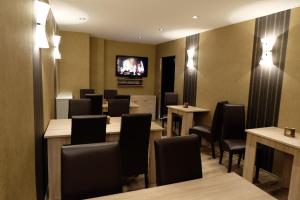 a waiting room with tables and chairs and a tv at Hotel Zum Weißen Roß in Winsen