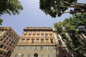 a tall brick building with a blue sky in the background at CASTRO PRETORIO SUITE - 1 bedroom flat, 2nd floor with lift, comfortable, quite, central, 2 steps from Termini Railway Station and metro A and B lines, a walk from Colosseum, Trevi Fountain, Spanish Steps, free welcome drinks in Rome