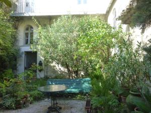 ヴィルヌーヴ・レ・ザヴィニョンにあるLe Cloitre du Couventの庭園内のテーブルとベンチ