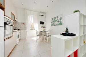 a kitchen with white cabinets and a table in it at CASTRO PRETORIO SUITE - 1 bedroom flat, 2nd floor with lift, comfortable, quite, central, 2 steps from Termini Railway Station and metro A and B lines, a walk from Colosseum, Trevi Fountain, Spanish Steps, free welcome drinks in Rome