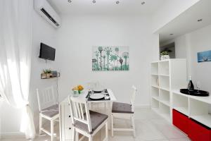 a white dining room with a white table and chairs at CASTRO PRETORIO SUITE - 1 bedroom flat, 2nd floor with lift, comfortable, quite, central, 2 steps from Termini Railway Station and metro A and B lines, a walk from Colosseum, Trevi Fountain, Spanish Steps, free welcome drinks in Rome