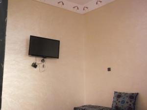 TV de pantalla plana en una pared con pájaros. en Hostel Merzouga Tifinagh en Merzouga