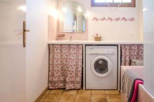 a bathroom with a washing machine and a sink at Les Granges du Bois Normand in Rueil-la-Gadelière