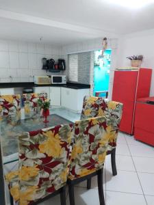 a kitchen with two chairs and a table in a kitchen at Suítes econômica 250 metros do mar in Piçarras