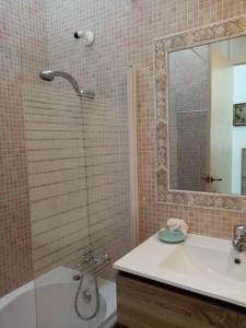 y baño con bañera, lavamanos y ducha. en Precioso apartamento en complejo con piscina en Cala'n Bosch
