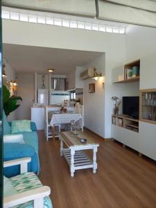a living room with a blue couch and a table at Precioso apartamento en complejo con piscina in Cala en Bosc