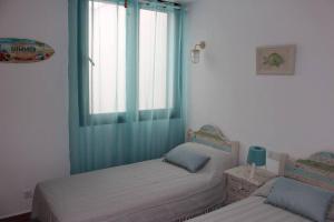 a bedroom with two twin beds and a window at Precioso apartamento en complejo con piscina in Cala'n Bosch