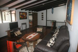 sala de estar con sofá de cuero y mesa en Casa La Eliana, en Salento
