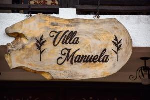 キンバヤにあるFinca Hotel Casa Nostra, Villa Manuelaの壁掛けのタリアマウリカを読む看板