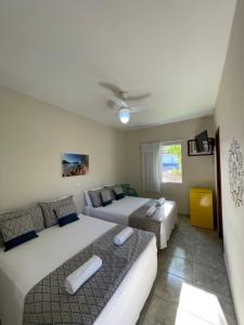 a bedroom with two beds and a couch at Pousada Serrate in Ubatuba