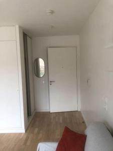 a white room with a door and a couch in it at Charmant appartement à la limite de Paris in Villejuif