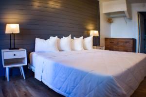 1 dormitorio con 1 cama grande con almohadas blancas en Devon Shores, en Clearwater Beach