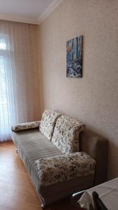 Gold Baku في باكو: أريكة في غرفة معيشة مع صورة على الحائط