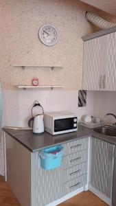 a kitchen with a microwave and a clock on the wall at Gold Baku in Baku