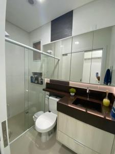 y baño con aseo, lavabo y ducha. en Apartamento aconchegante a 200 metros da praia en Florianópolis