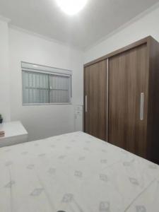 1 dormitorio con 1 cama y armario de madera en Apartamento aconchegante a 200 metros da praia en Florianópolis