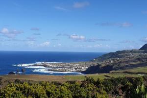 a view of the ocean and a town on a hill at Casa da Ribeira - Mosteiros in Mosteiros