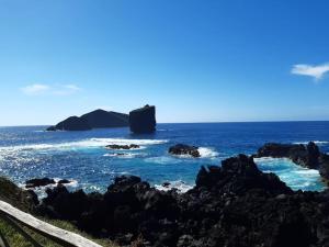 a view of the ocean with rocks in the water at Casa da Ribeira - Mosteiros in Mosteiros