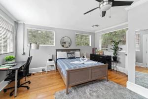 a bedroom with a bed and a desk and windows at Chic ATL Studio - 5 mins walk Emory CDC in Atlanta