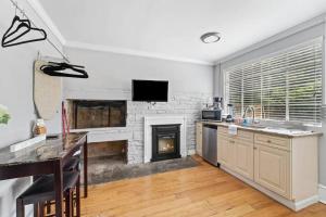 a kitchen with a fireplace and a table and a counter at Chic ATL Studio - 5 mins walk Emory CDC in Atlanta