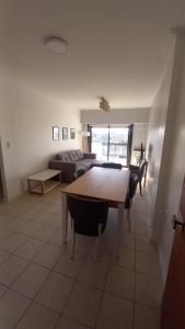 uma sala de estar com uma mesa e um sofá em Departamentos 3 Ambientes Cochera Punta Mogotes em Mar del Plata