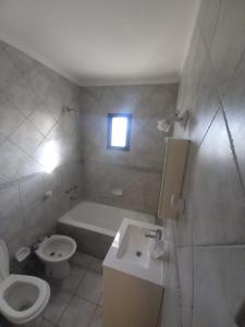 a bathroom with a toilet and a sink and a tub at Departamentos 3 Ambientes Cochera Punta Mogotes in Mar del Plata