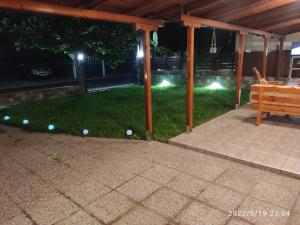 einen Hinterhof mit einem Pavillon in der Nacht mit Bällen im Gras in der Unterkunft Verde Home in Néa Meságkala