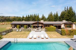 a home with a swimming pool and a house at Wanaka Haven in Wanaka