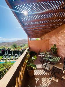 a patio with a table and chairs on a balcony at Les terrasses du Lac Marrakech in Lalla Takerkoust