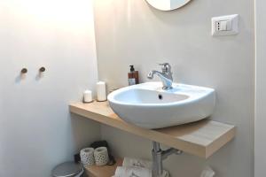 ein Badezimmer mit einem weißen Waschbecken und einem Spiegel in der Unterkunft Vicolo Fiore Affittacamere in Matera