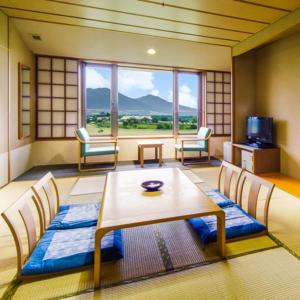 Habitación con mesa, sillas y ventana grande. en Kyukamura Hiruzen-Kogen, en Maniwa