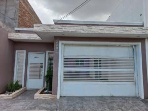 un garage avec une porte blanche devant une maison dans l'établissement Privacidad y comodidad, à Los Mochis