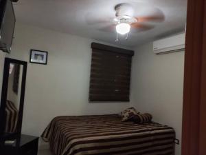 - une chambre avec un ventilateur de plafond et un lit dans l'établissement Privacidad y comodidad, à Los Mochis