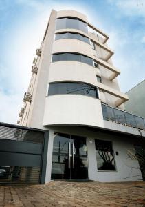 烏貝蘭迪亞的住宿－Aero Inn Hotel，一座高大的白色建筑,玻璃门