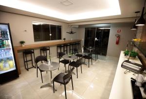 un restaurante con mesas y sillas y un bar en Aero Inn Hotel, en Uberlândia