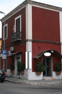 een rood gebouw met potplanten ervoor bij JLL Room in Foggia