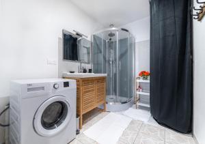 uma casa de banho com uma máquina de lavar roupa e um chuveiro em Au cœur de joigny em Joigny