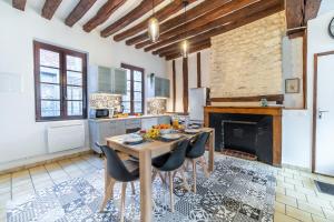 cocina con mesa, sillas y chimenea en Au cœur de joigny, en Joigny
