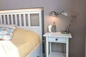 ein Bett mit einer Lampe auf einem Nachttisch neben einem weißen Bett in der Unterkunft Vicolo Fiore Affittacamere in Matera