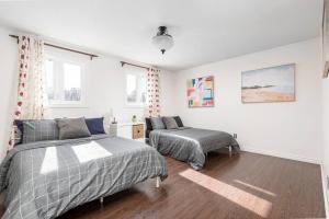 1 dormitorio con 2 camas y ventana en Central 4 Bed Room Home by GO Station and Sq One!, en Mississauga