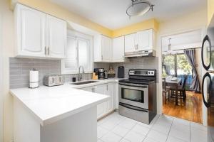 a kitchen with white cabinets and a stove top oven at Central 4 Bed Room Home by GO Station and Sq One! in Mississauga