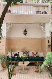 um pátio com um sofá verde e uma mesa em Riad Maison 24 em Marrakech