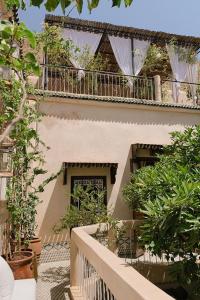 uma varanda de um edifício com plantas sobre ele em Riad Maison 24 em Marrakech