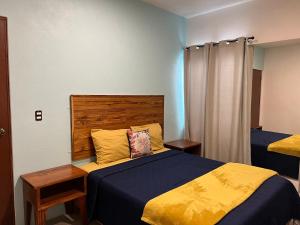 a bedroom with a bed with a blue and yellow blanket at Mini loft “FRIDA” in La Paz