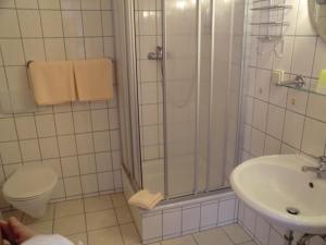 e bagno con doccia, servizi igienici e lavandino. di Hotel Zum Schneekopf "Garni" a Gehlberg