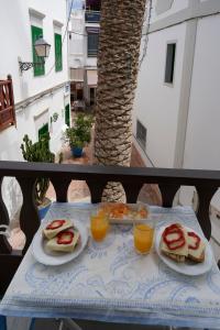 een tafel met sandwiches en jus d'orange bij The Palm House in Puerto de Mogán