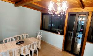 ein Esszimmer mit einem Tisch, Stühlen und einem Kronleuchter in der Unterkunft Roxy Alto Belvedere in Casale la Cogna
