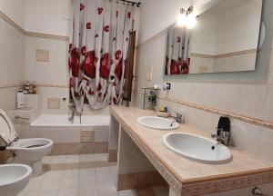 ein Badezimmer mit zwei Waschbecken, einem WC und einer Badewanne in der Unterkunft Roxy Alto Belvedere in Casale la Cogna