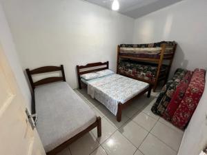 Habitación con 2 camas, mesa y sillas en Casa Temporada en Ubatuba