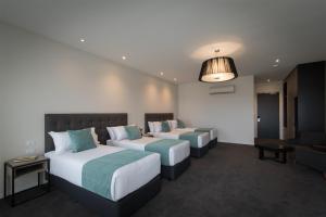 Habitación de hotel con 2 camas y sofá en Rye Hotel - One Four Nelson en Rye